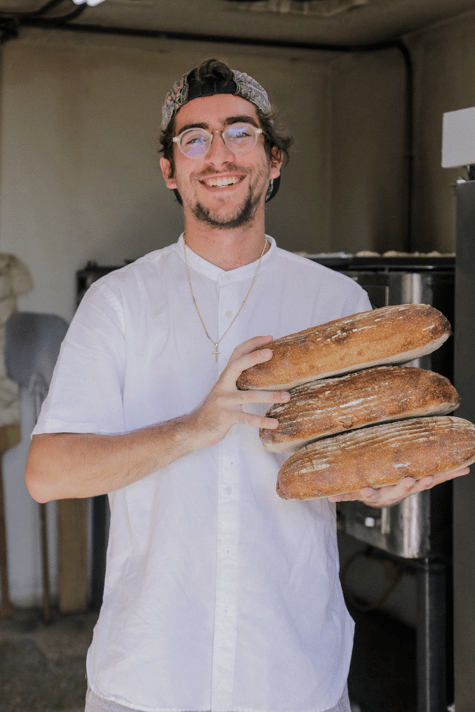 Diego con tres hogazas de pan en sus manos.